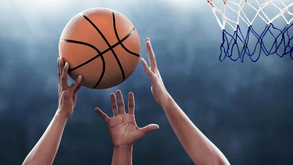 Close-up of a player catching a basketball with proper form, creating a window with their hands to absorb the impact on their palms and finger pads